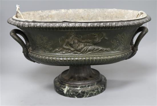 An oval cast iron classical French planter with marble plinth length 41cm